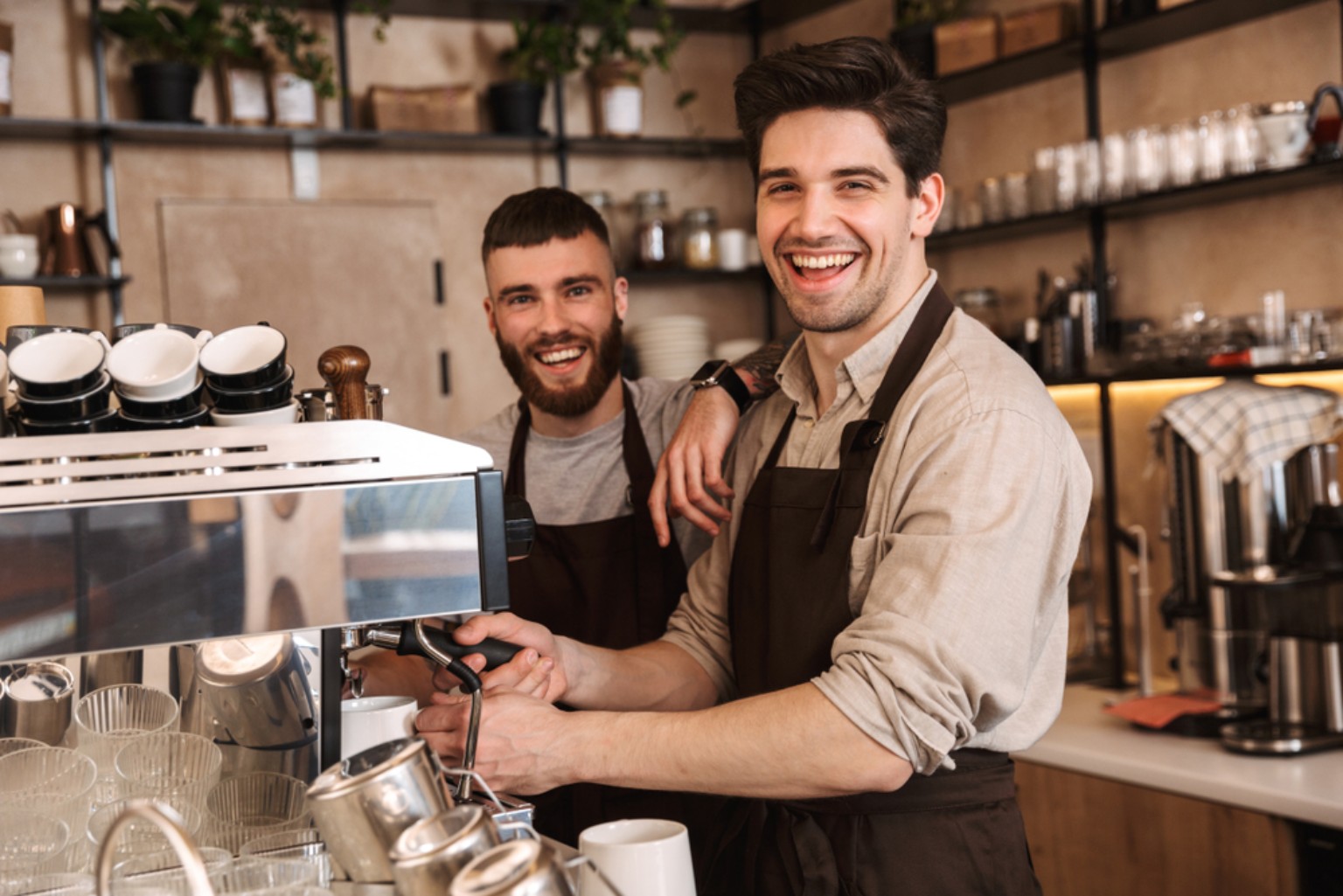 Baristas smiling behind the espresso machine