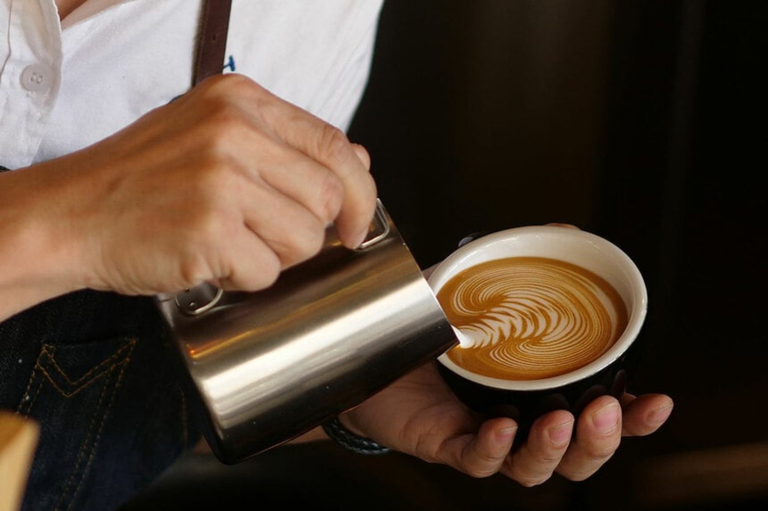 Latte art being poured into a cup